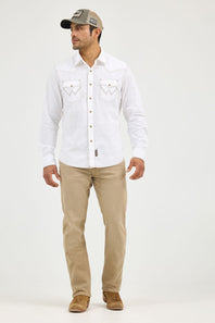A man modeling a white long-sleeve western-style button-up shirt with embroidered chest pockets, paired with khaki pants, brown boots, and a gray baseball cap against a plain light gray studio background.