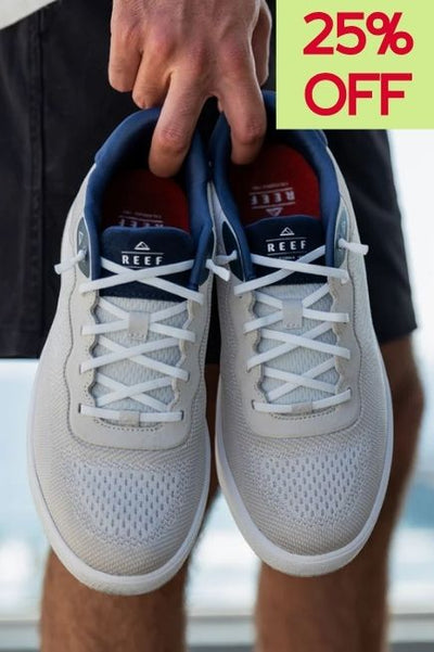 Persson holding a pair of tan sneakers with red insole and 