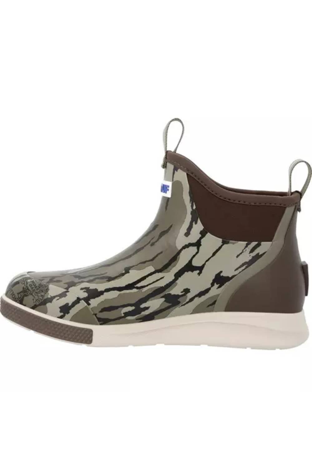 A single rubber ankle boot with a green and black bark-like camouflage pattern, brown elastic side panels, a brown pull tab, and a thick off-white sole.