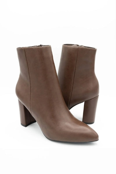 A pair of brown ankle height heeled boots on a white background