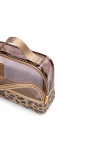 A clear zippered cosmetic pouch with a leopard print base and a metallic rose gold handle, shown on a plain white background.