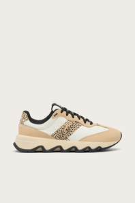A low-top sneaker in beige, white, and black, featuring a leopard-print side panel, black laces, and a wavy black sole, shown against a light beige background.