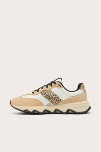 A low-top sneaker in beige and off-white suede and mesh, featuring a leopard-print pattern panel on the side and black laces, shown against a light beige background.