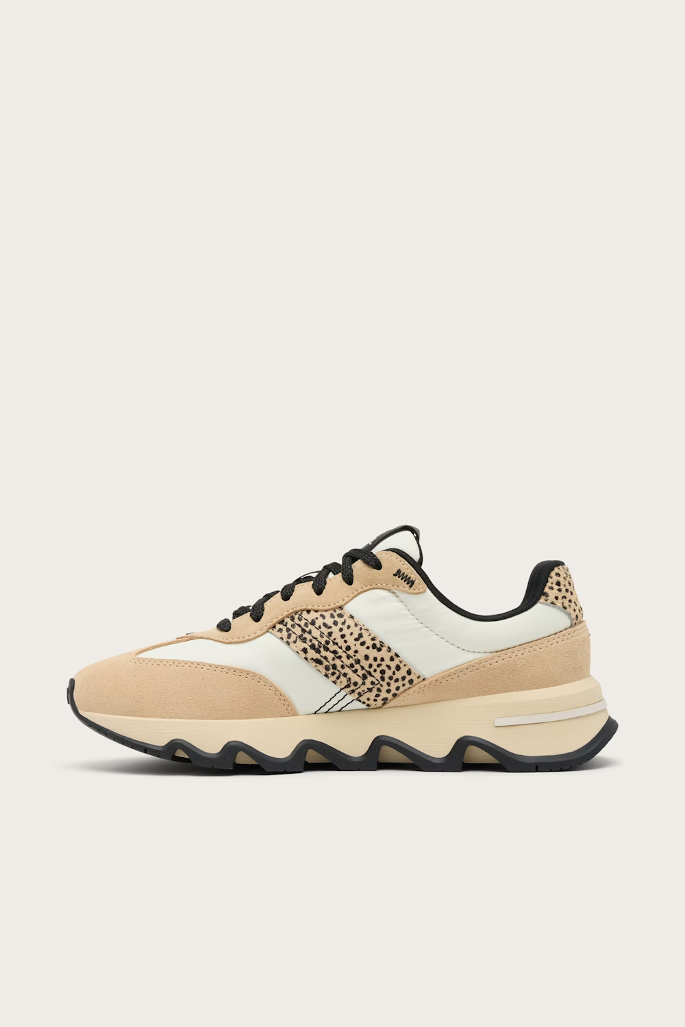 A low-top sneaker in beige and off-white suede and mesh, featuring a leopard-print pattern panel on the side and black laces, shown against a light beige background.