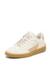 A low-top sneaker in off-white leather with beige suede side panels, beige speckled laces, and a gum brown sole, shown on a plain white background.