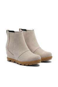 A pair of women's wedge ankle boots in a light taupe-beige suede-like material with elastic side panels and a brown lug sole, shown on a plain white background.