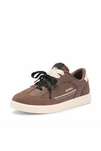 A brown suede and leather low-top sneaker by  featuring black laces, a cream-colored tongue detail, and a cream midsole and outsole.