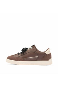 A low-top sneaker in brown suede and leather with black laces, a cream heel tab, and a thick cream midsole, shown from a side profile on a white background.