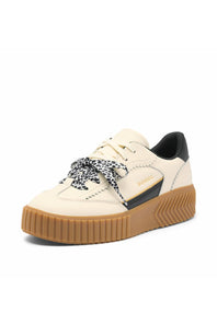 A low-top platform sneaker in cream and black with a brown gum sole and patterned laces, shown on a plain white background.