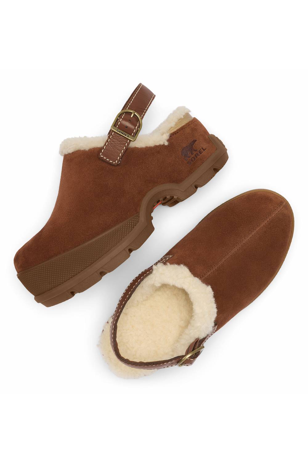 A pair of brown suede slip-on clogs with a cream shearling lining and a brown strap with a gold-tone buckle, shown on a plain white background.