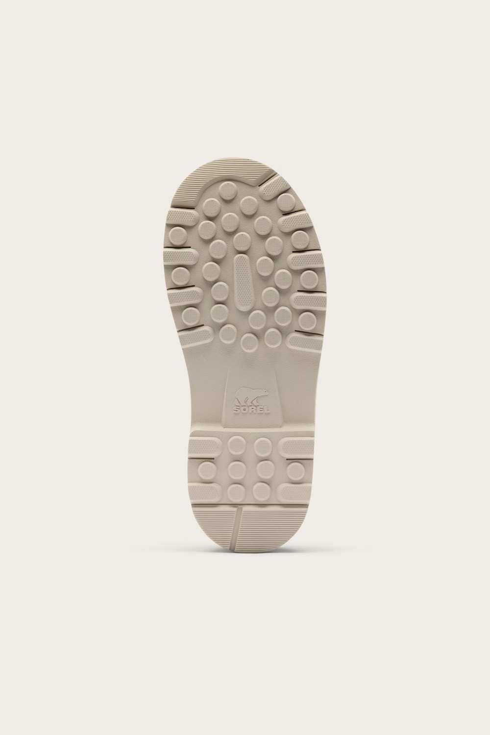 The bottom sole of a light beige shoe, showing a textured tread pattern and a small embossed logo, set against a solid off-white background.