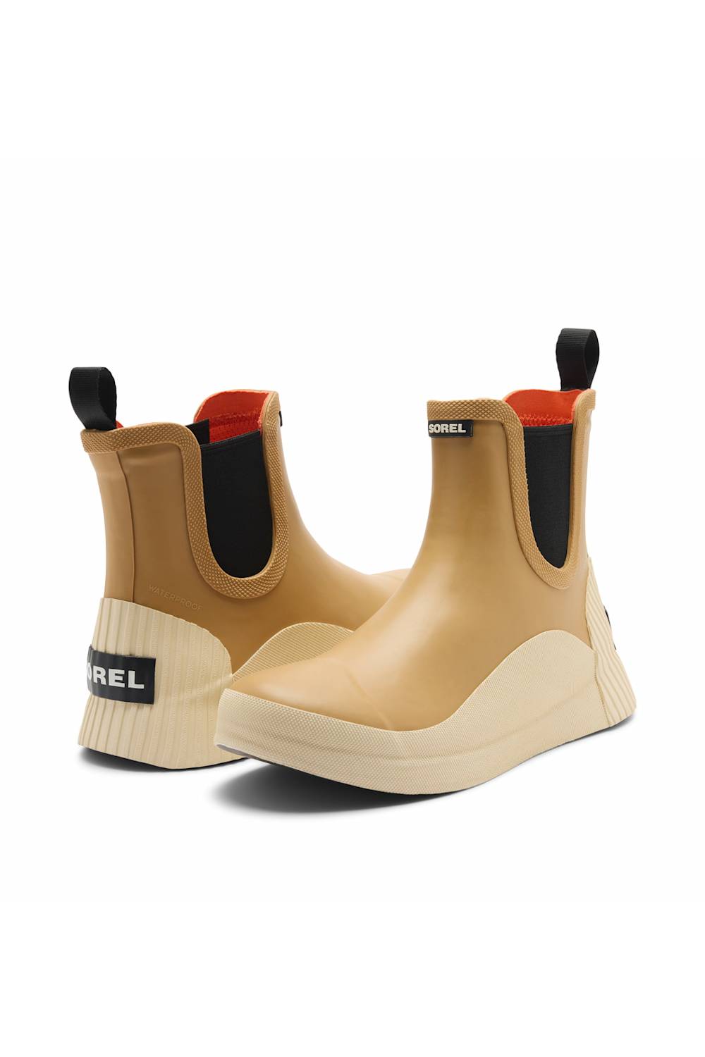 A pair of ankle rain boots in beige and tan, featuring black elastic side panels, a black pull tab, and a cream-colored wedge sole.