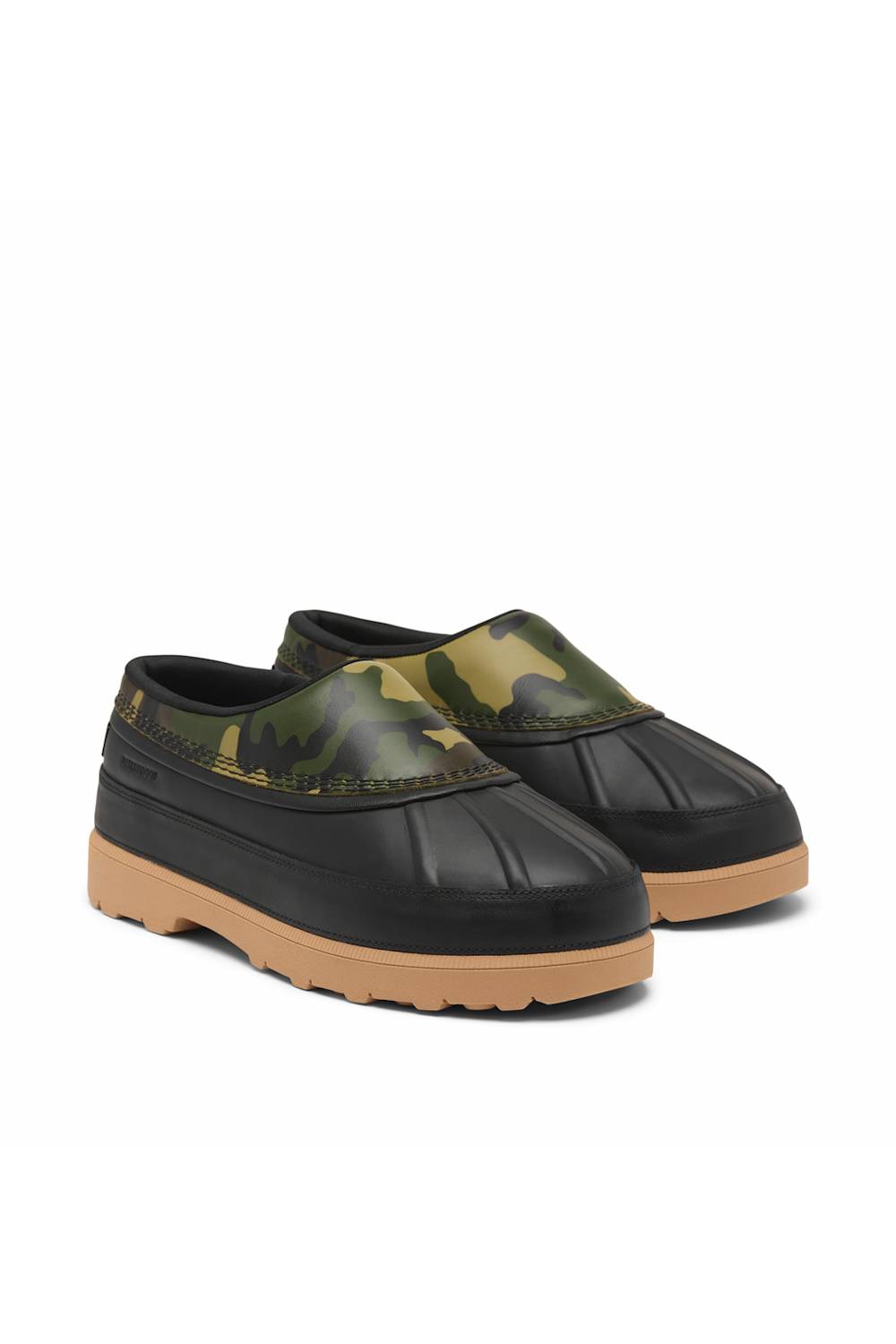 A pair of slip-on clogs with black rubber toes and heels, a green camouflage pattern across the upper, and tan soles, shown on a plain white background.