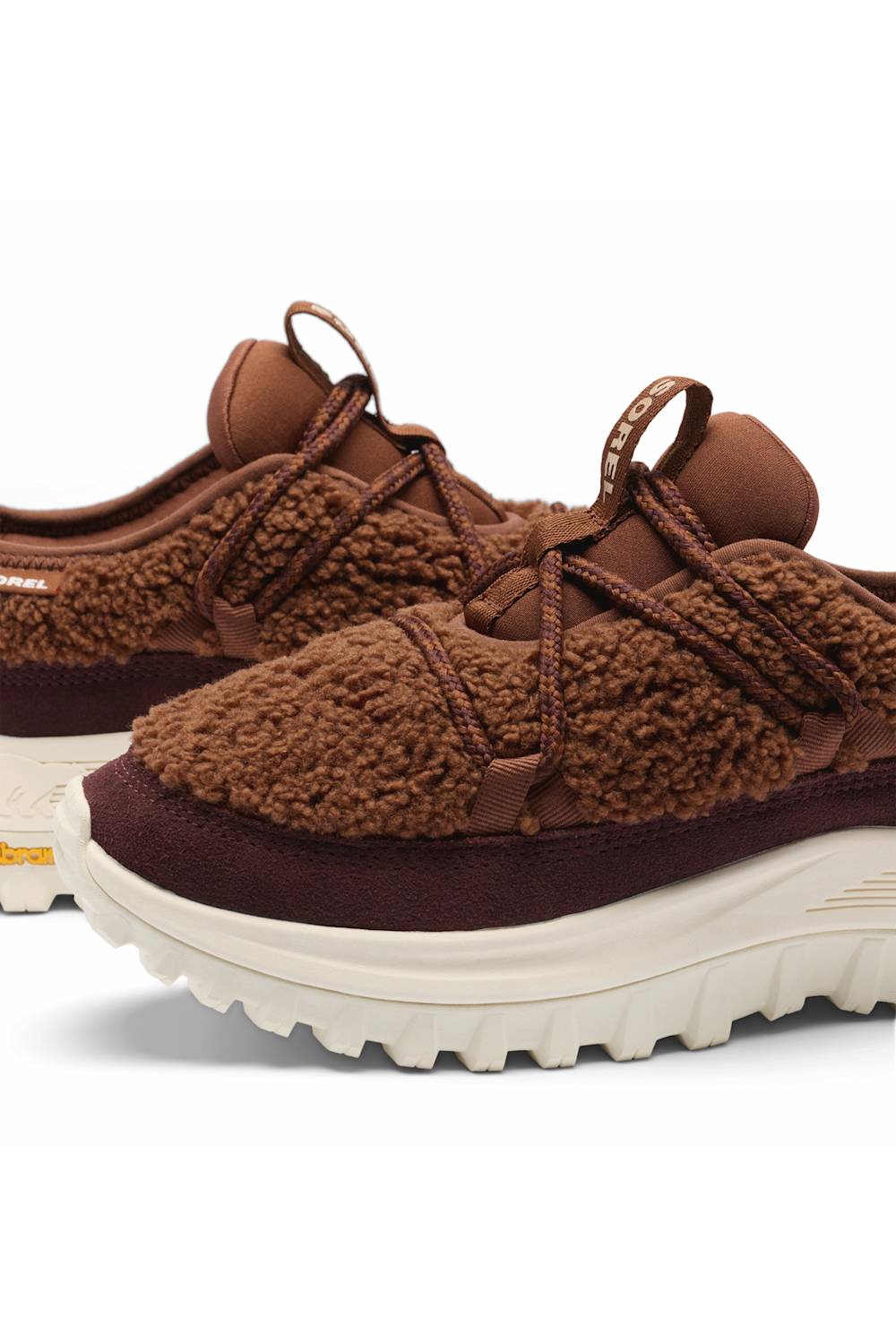A pair of brown fuzzy lace-up sneakers with dark brown suede-like panels and thick off-white rubber soles, shown on a clean white background.