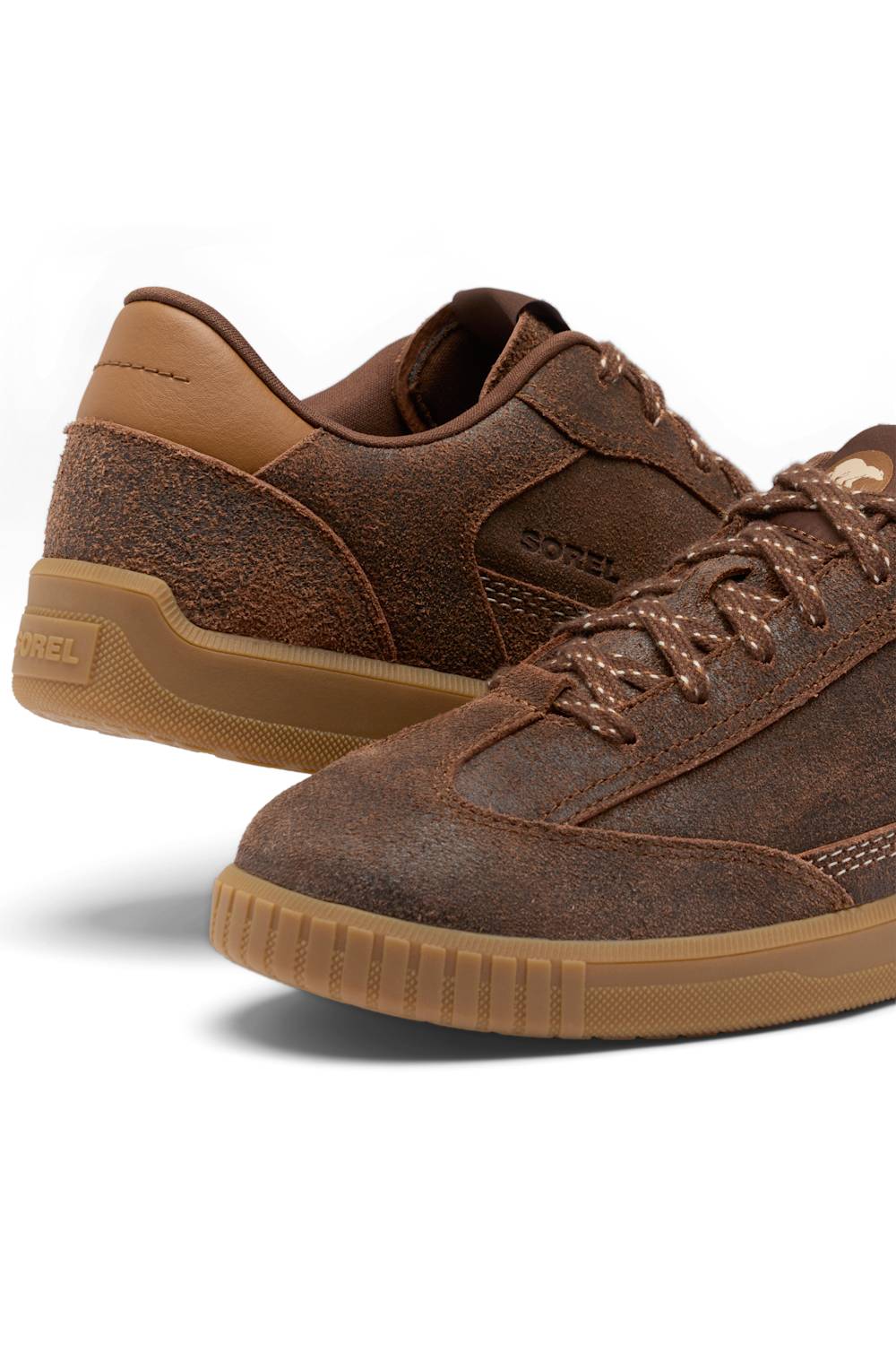 A pair of brown suede and textured leather sneakers with matching brown laces and tan gum soles, shown on a clean white background.