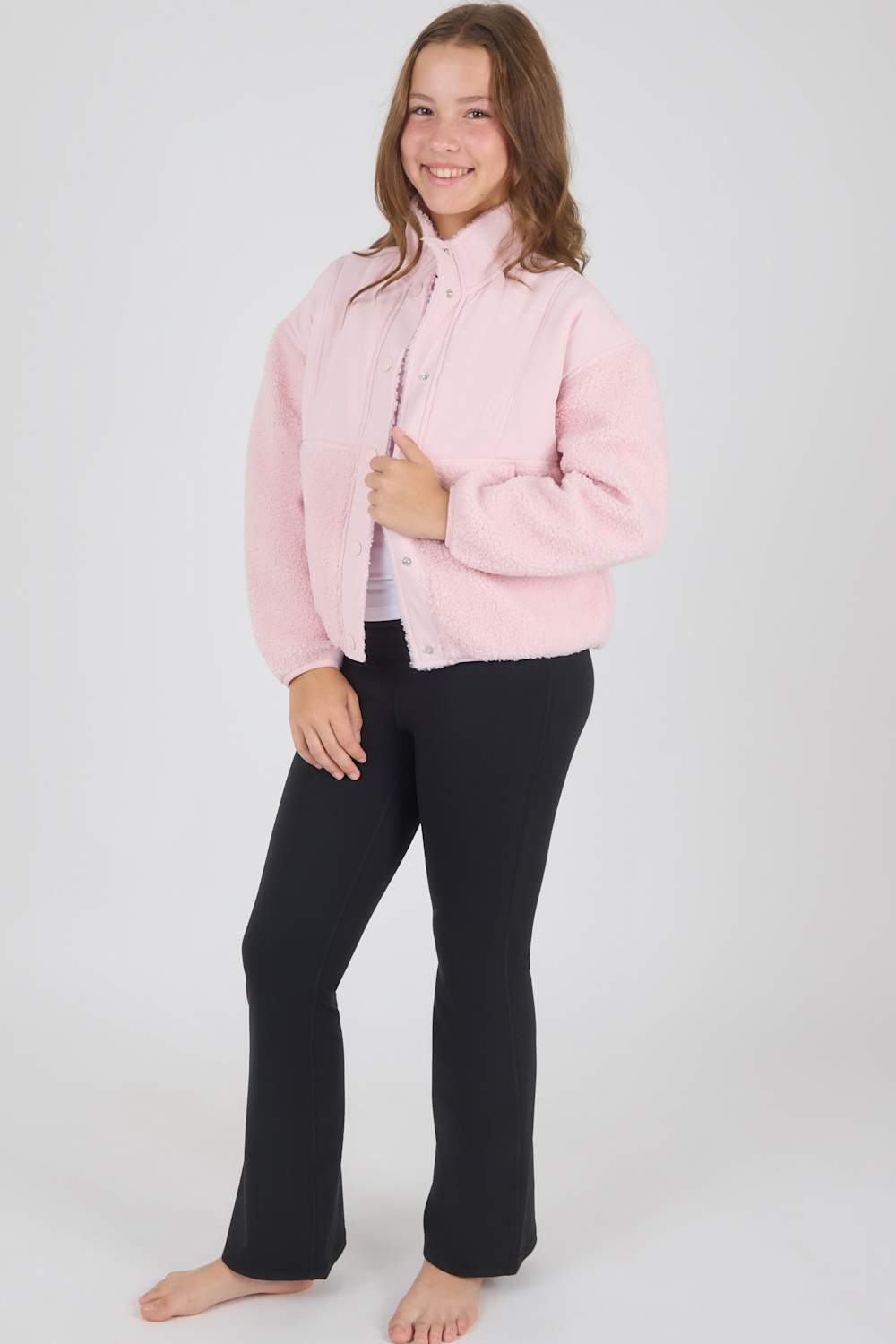 Girl modeling a pink sherpa jacket and flare leggings outfit