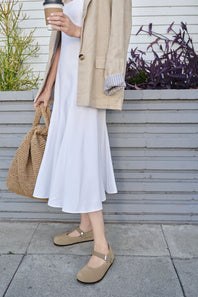 A single women's Mary Jane flat shoe in a light taupe suede-like material, featuring a wide strap with a silver-tone buckle and a black outsole, shown on a white background.