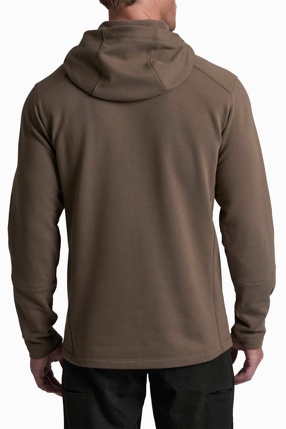 A man viewed from the back wearing a brown hooded sweatshirt and black pants against a plain white background.