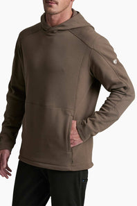 A man wearing a brown hooded sweatshirt with a kangaroo pocket and a zippered front, paired with black pants, shown against a plain white background.