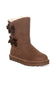 A brown suede ankle boot with decorative dark brown bows on the side and a soft cream-colored shearling lining visible at the top, set against a plain white background.