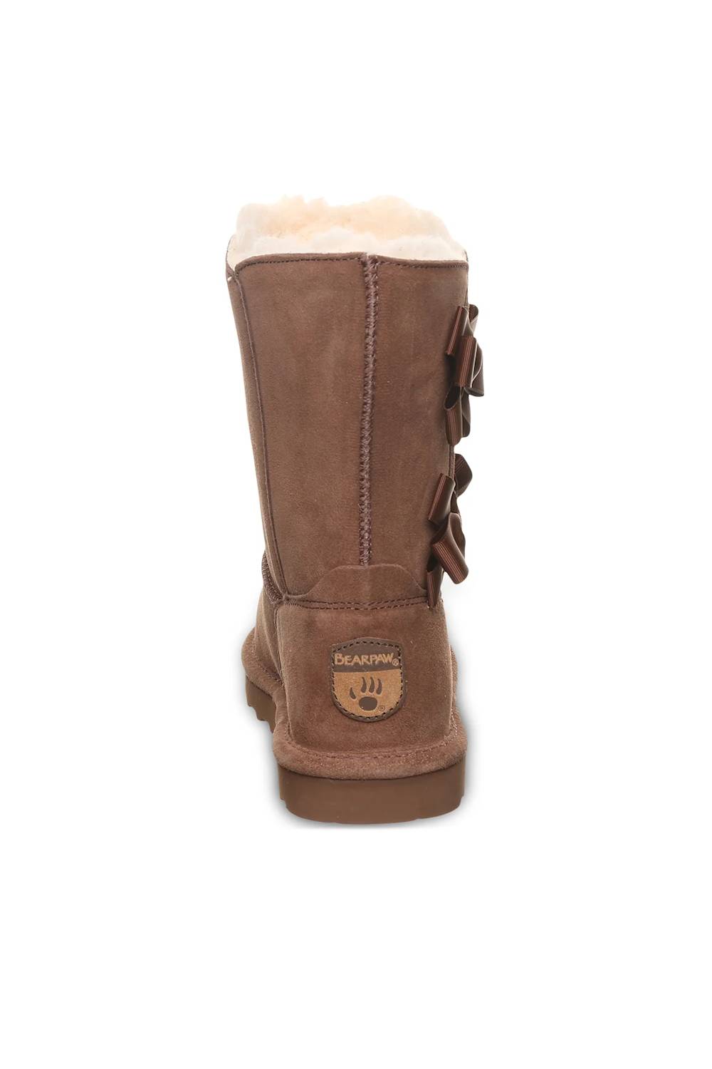 A brown suede mid-calf boot with a soft cream shearling lining at the top and decorative side bows, shown from the back on a white background.