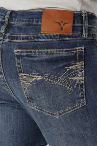 Close-up of the back waistband and pocket area of blue denim jeans, showing a brown leather patch with a black longhorn logo and decorative contrast stitching on the back pocket.