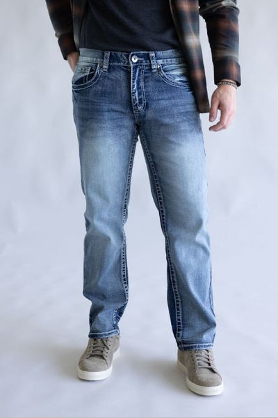 Man wearing blue jeans and a plaid shirt on a plain background