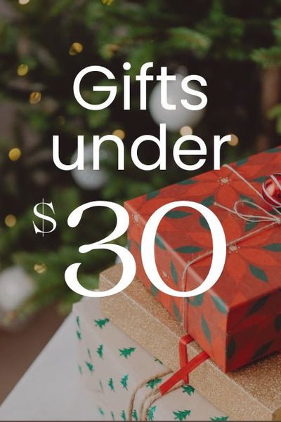 Gifts under $30 with a blurred Christmas tree in the background