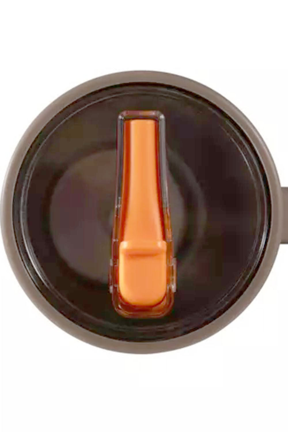 Close-up of a dark brown insulated tumbler lid with a translucent orange flip-straw insert, shown against a plain white background.