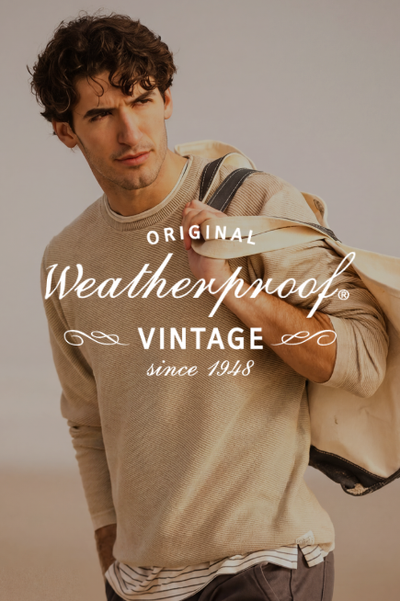 Young man in casual sweater holding bag over shoulder, on a sandy beach. Text reads 