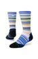 A pair of crew socks with a striped pattern in shades of blue, navy, beige, white, and lime green, featuring solid black heels, toes, and heels. A small white Stance logo is visible on the upper cuff.