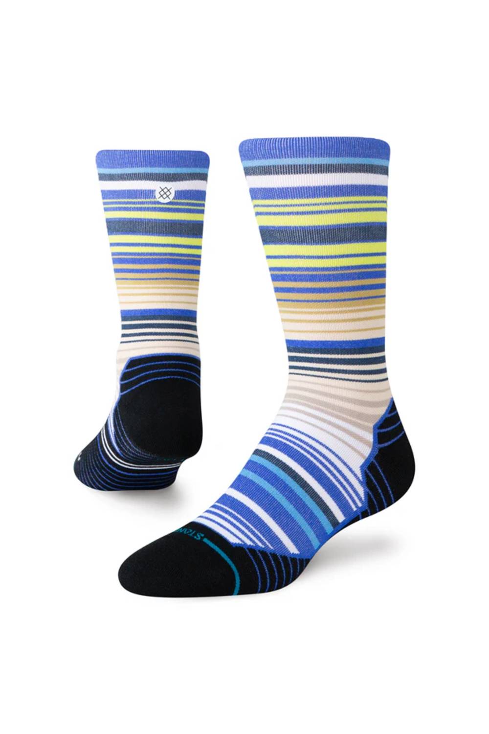 A pair of crew socks with a striped pattern in shades of blue, navy, beige, white, and lime green, featuring solid black heels, toes, and heels. A small white Stance logo is visible on the upper cuff.