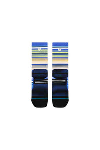 A pair of Stance crew socks featuring a striped pattern in blue, navy, green, yellow, and beige, with solid black toe and heel caps, shown against a plain white background.