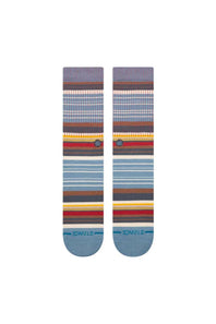 A pair of Stance crew socks with a multicolor striped pattern in shades of blue, brown, red, yellow, and white, featuring the Stance brand name on the toes.