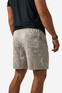 A man wearing light beige and gray patterned athletic shorts, shown from the back against a plain white background.