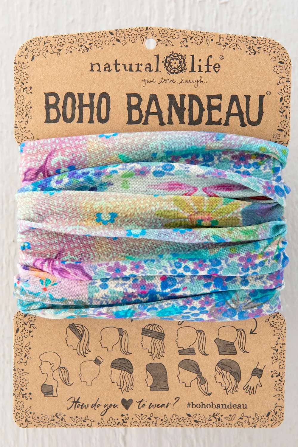 Natural Life Boho Bandeau headwrap in a multicolor floral print, presented on its original kraft paper packaging card.
