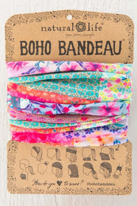 Natural Life Boho Bandeau headwrap in a multicolor floral and patterned fabric, packaged on a brown kraft paper card with instructions on how to wear it.