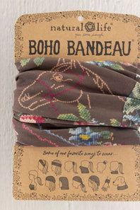 A brown fabric boho headband with a colorful horse and floral pattern, packaged on a brown kraft paper card labeled 'natural life BOHO BANDEAU'.
