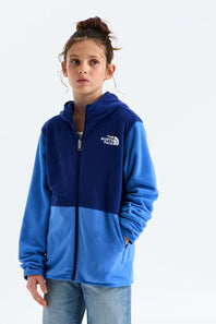 A girl wearing a colorblock fleece zip-up hoodie by The North Face. The hoodie features a dark navy blue upper section and a bright blue lower section, with a white embroidered logo on the left chest.