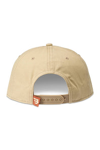 The back view of a khaki snapback cap with a tan adjustable strap and a small orange brand tag featuring a white stylized logo.