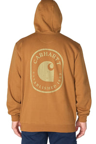 A man wearing a brown Carhartt hoodie and blue jeans stands