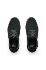 A pair of dark green suede low-top sneakers shown from a top-down view on a white background, featuring gray laces and a black interior with a visible Reef logo.