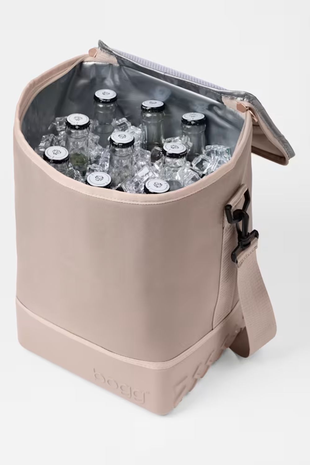 A beige cooler bag with a silver zipper and interior, shown open and filled with clear bottles and ice. The brand name 'badef' is subtly embossed on the bottom front.