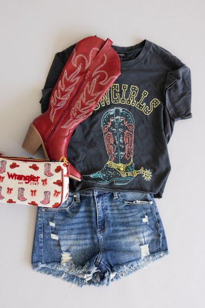 Women's flat lay outfit featuring dark wash distressed denim shorts, graphic tee with 