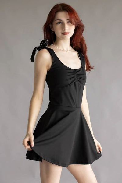 Woman wearing a short Simply Southern black athletic dress in front of a plain background