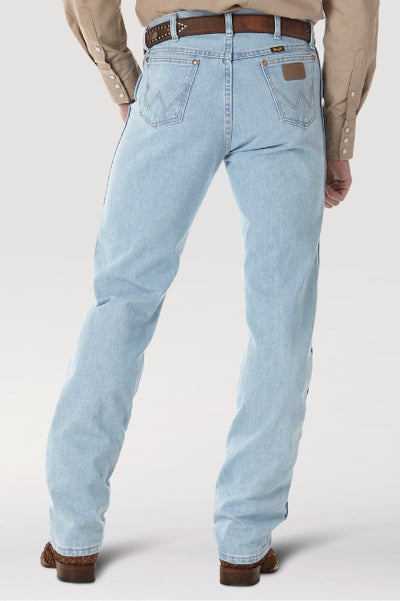 Back view of a model wearing light-wash straight-leg jeans with stitched back pockets, paired with a tan button-up shirt, brown belt, and brown boots against a light gray background.