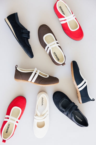 An overhead view of eight Mary Jane-style shoes laying on a white background 