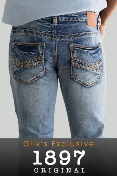 A person viewed from the back wearing medium wash denim jeans with tan stitching and a brown leather brand label above the right back pocket. A black promotional banner at the bottom reads GLIK'S EXCLUSIVE 1897 ORIGINAL