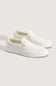 A pair of white slip-on platform sneakers with a subtle embossed pattern, displayed on a light beige background.