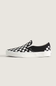 A single Vans slip-on platform sneaker in a black and white checkerboard pattern, shown from the side against a light beige background.